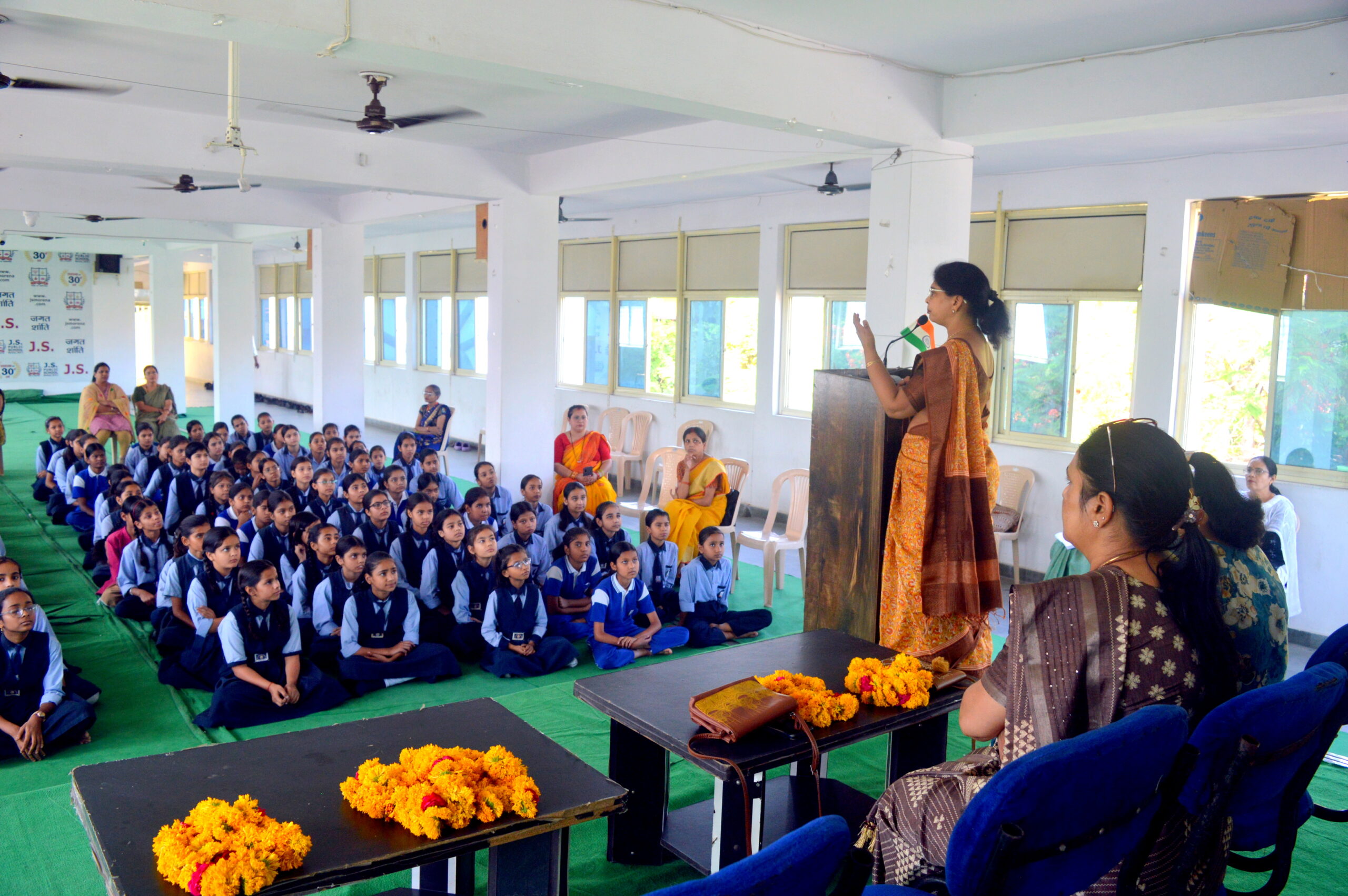 Speaker addressing students during Good Touch Bad Touch awareness session at JS Public School Morena with attentive schoolgirls seated in the hall